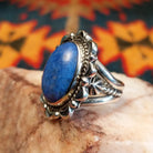 Sterling silver ring with denim lapis set in the bezel, framed by ornate and frilled silverwork.