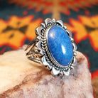 Sterling silver ring with denim lapis set in the bezel, framed by ornate and frilled silverwork.