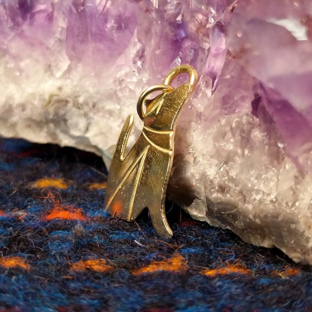 Polished gold coyote pendant.