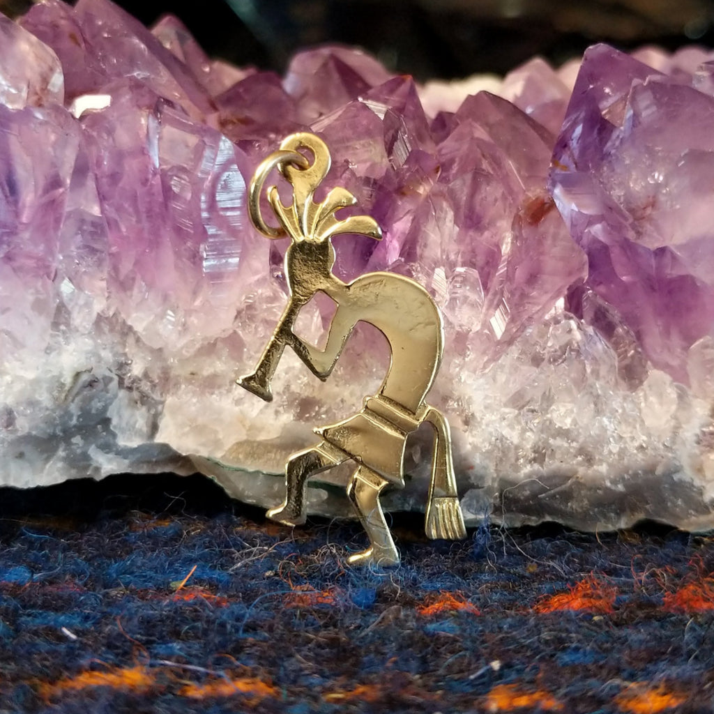 Navajo gold Kokopelli pendant with flute-playing figure.