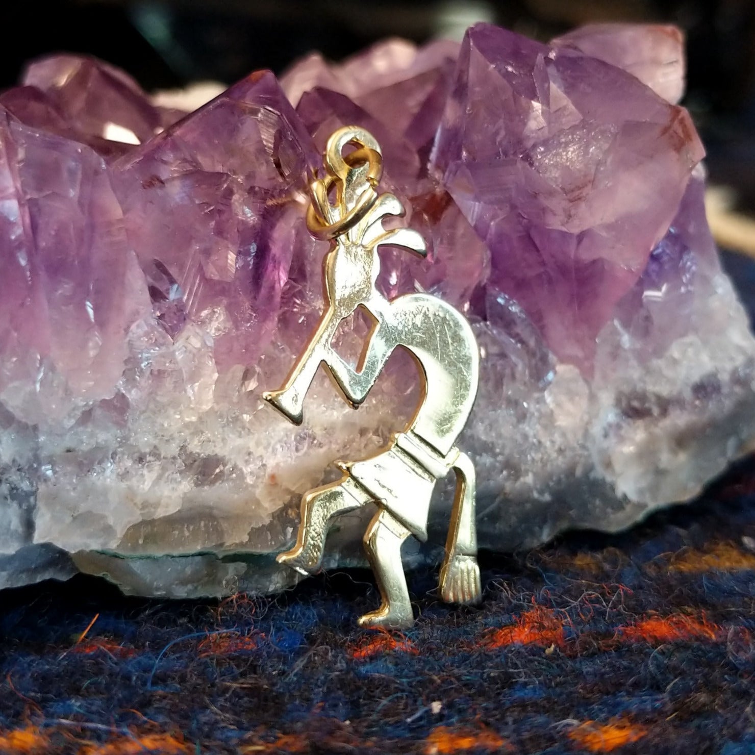 Navajo gold Kokopelli pendant with flute-playing figure.