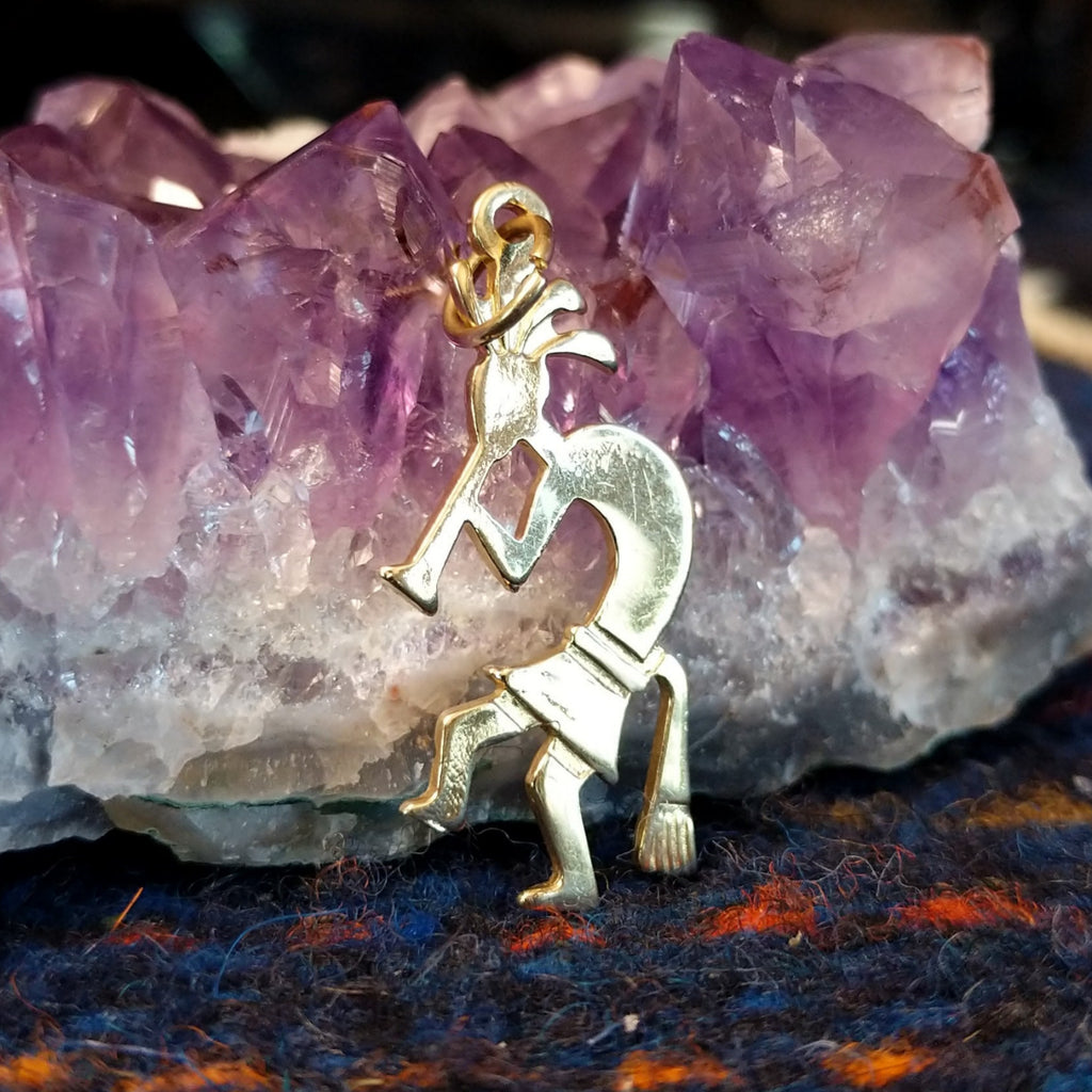 Navajo gold Kokopelli pendant with flute-playing figure.