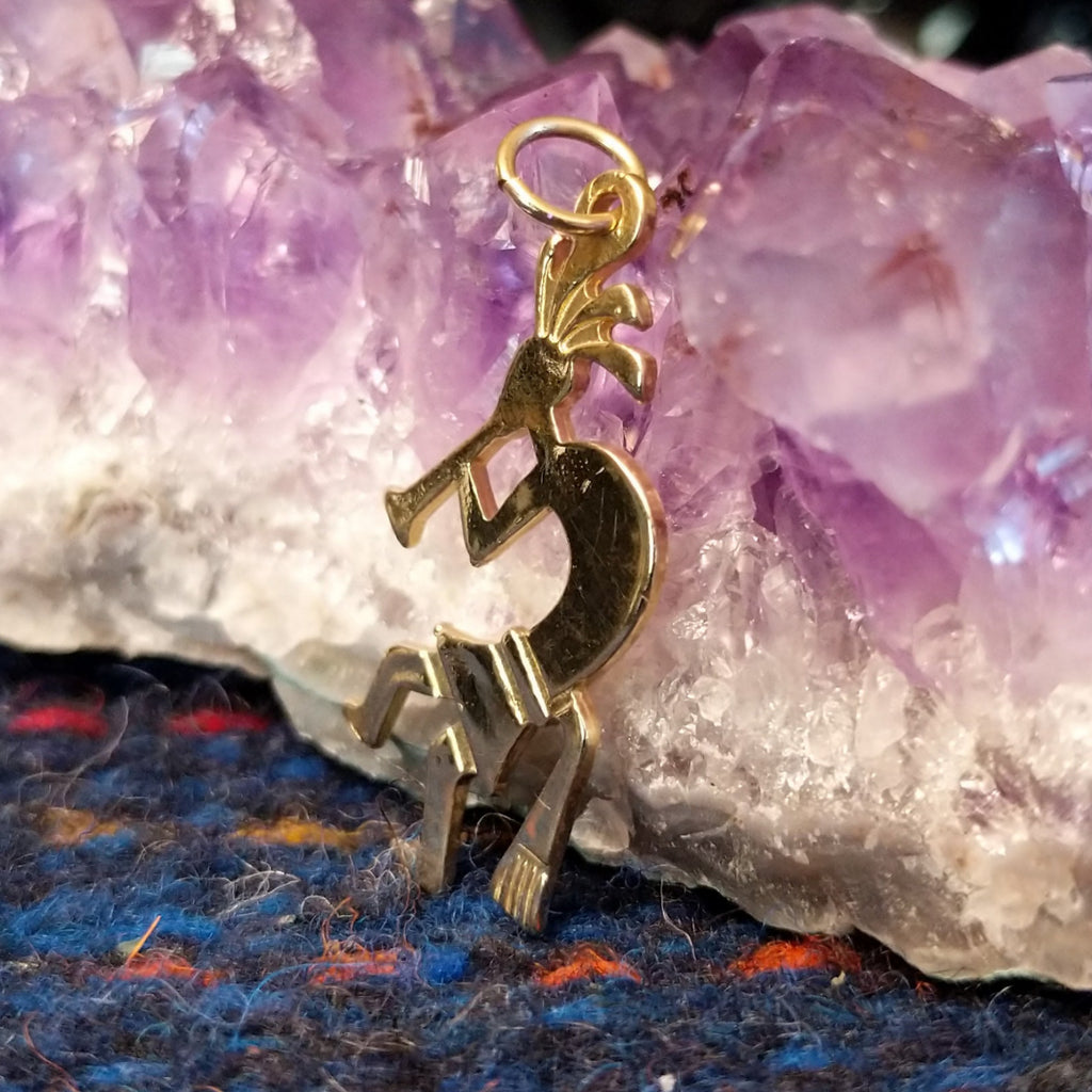 Navajo gold Kokopelli pendant with flute-playing figure.