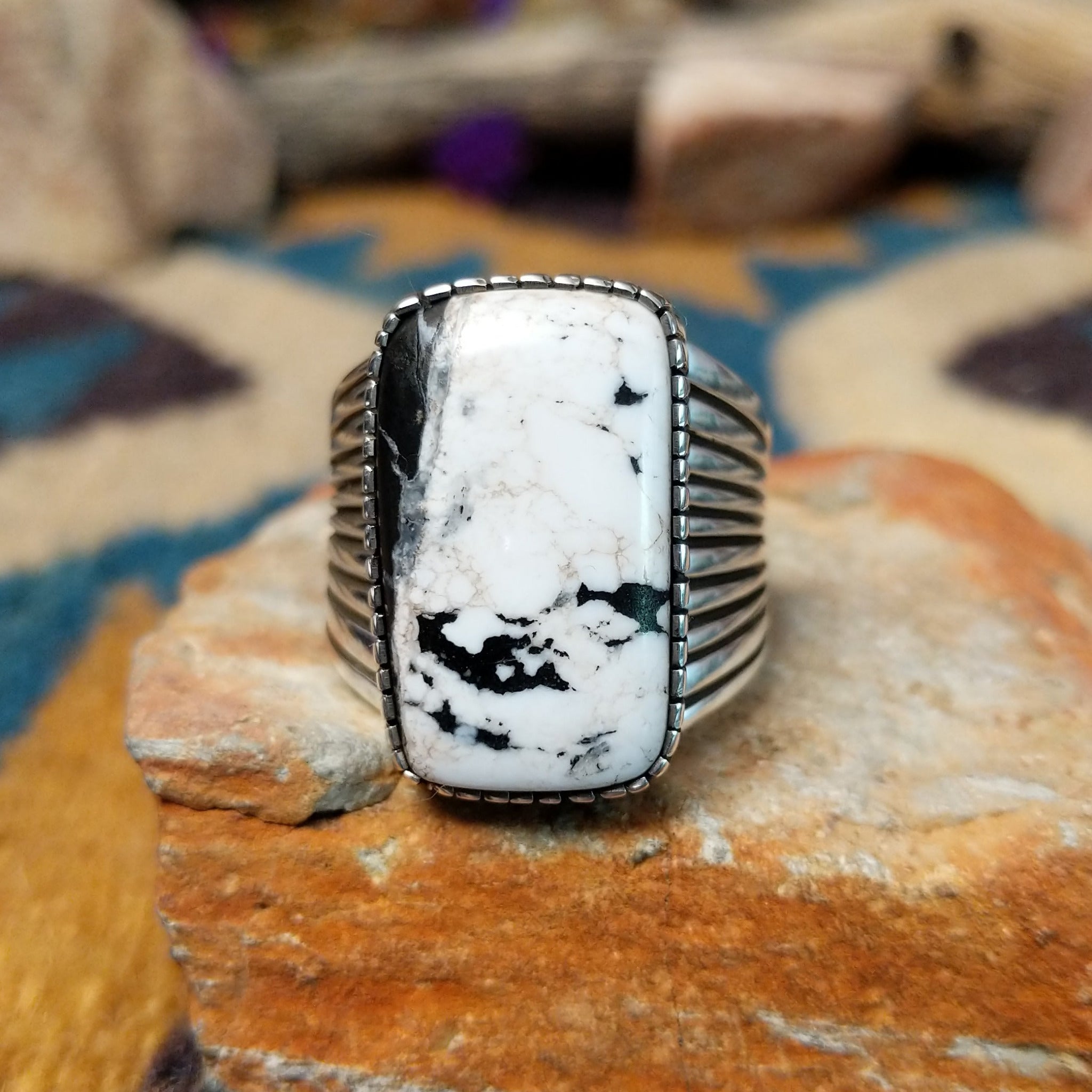 Sterling silver White Buffalo ring by J.P. featuring a rectangular White Buffalo stone with black veining, serrated bezel, and grooved split-shank Southwestern design.