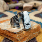 Sterling silver White Buffalo ring by J.P. featuring a rectangular White Buffalo stone with black veining, serrated bezel, and grooved split-shank Southwestern design; side view.