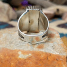 Sterling silver White Buffalo ring by J.P. featuring a rectangular White Buffalo stone with black veining, serrated bezel, and grooved split-shank Southwestern design; underside view.