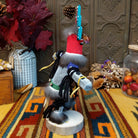 This vibrant Navajo Hemis Kachina by Debbie James features a hand-painted red and turquoise mask, stepped headdress, natural feathers, soft fur accents, leather ties, and a circular wooden display base; side view.
