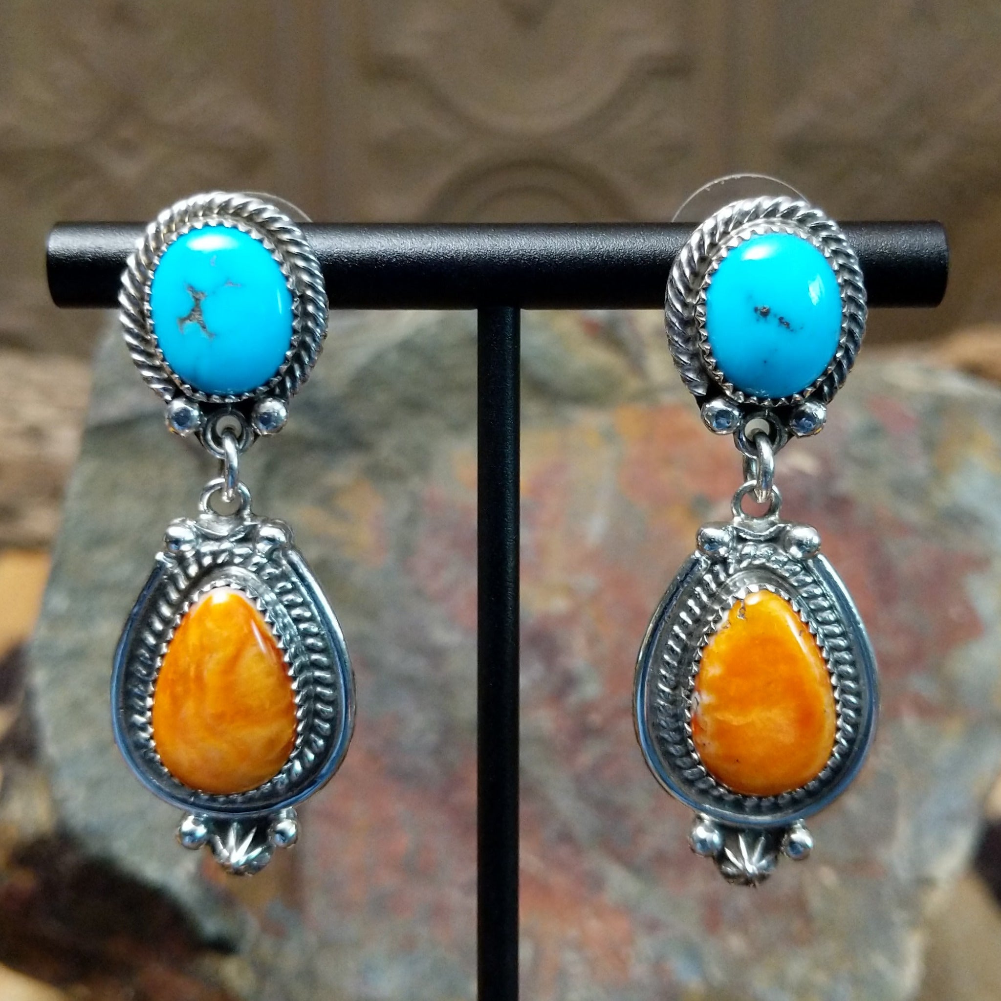 Handcrafted sterling silver Navajo Kingman turquoise and orange spiny oyster earrings, featuring a two-stone dangle design with traditional rope and stamped silver details.