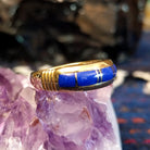 Side view of the smooth gold band showing lapis segments.