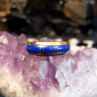 A gold band ring with segmented lapis inlay.