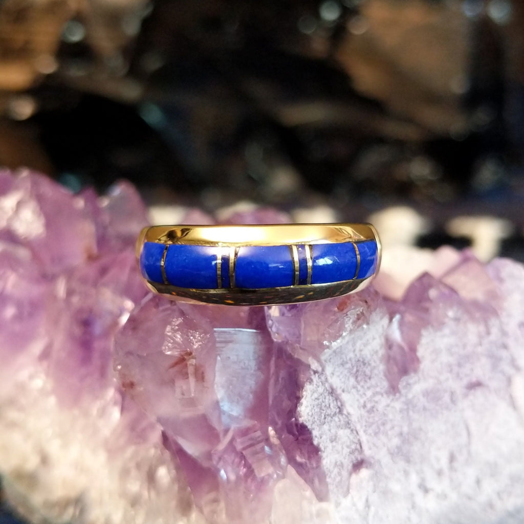 A gold band ring with segmented lapis inlay.