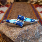 Flowing jewelry set with matching necklace, earrings, and cuff featuring lapis and manmade opal inlays.