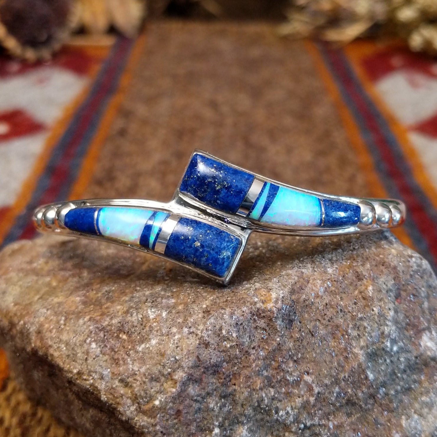 Flowing jewelry set with matching necklace, earrings, and cuff featuring lapis and manmade opal inlays.