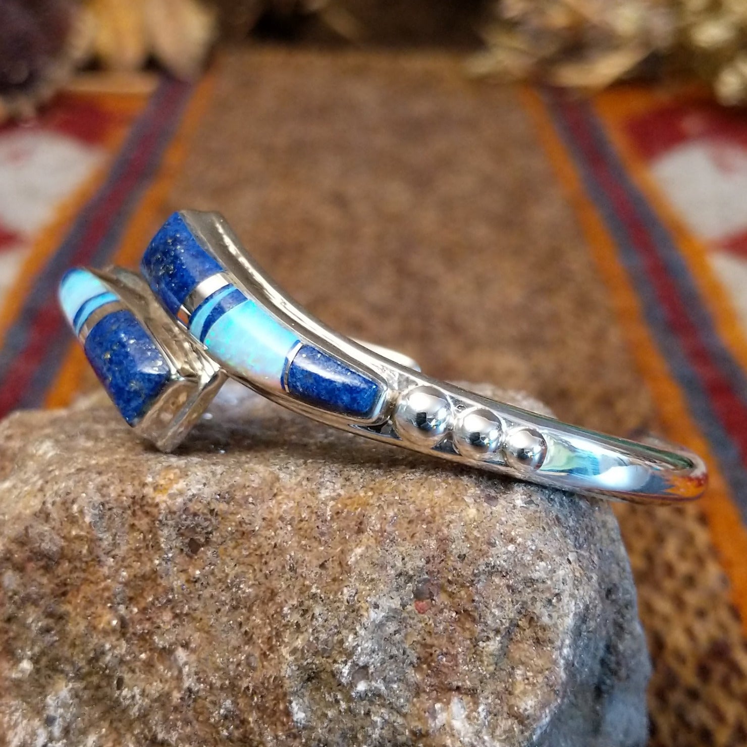 Flowing jewelry set with matching necklace, earrings, and cuff featuring lapis and manmade opal inlays.