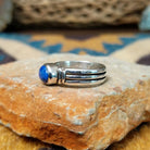 Handcrafted sterling silver Navajo lapis oval ring by D.C., featuring a rich blue oval lapis gemstone in a classic bezel setting; side view.