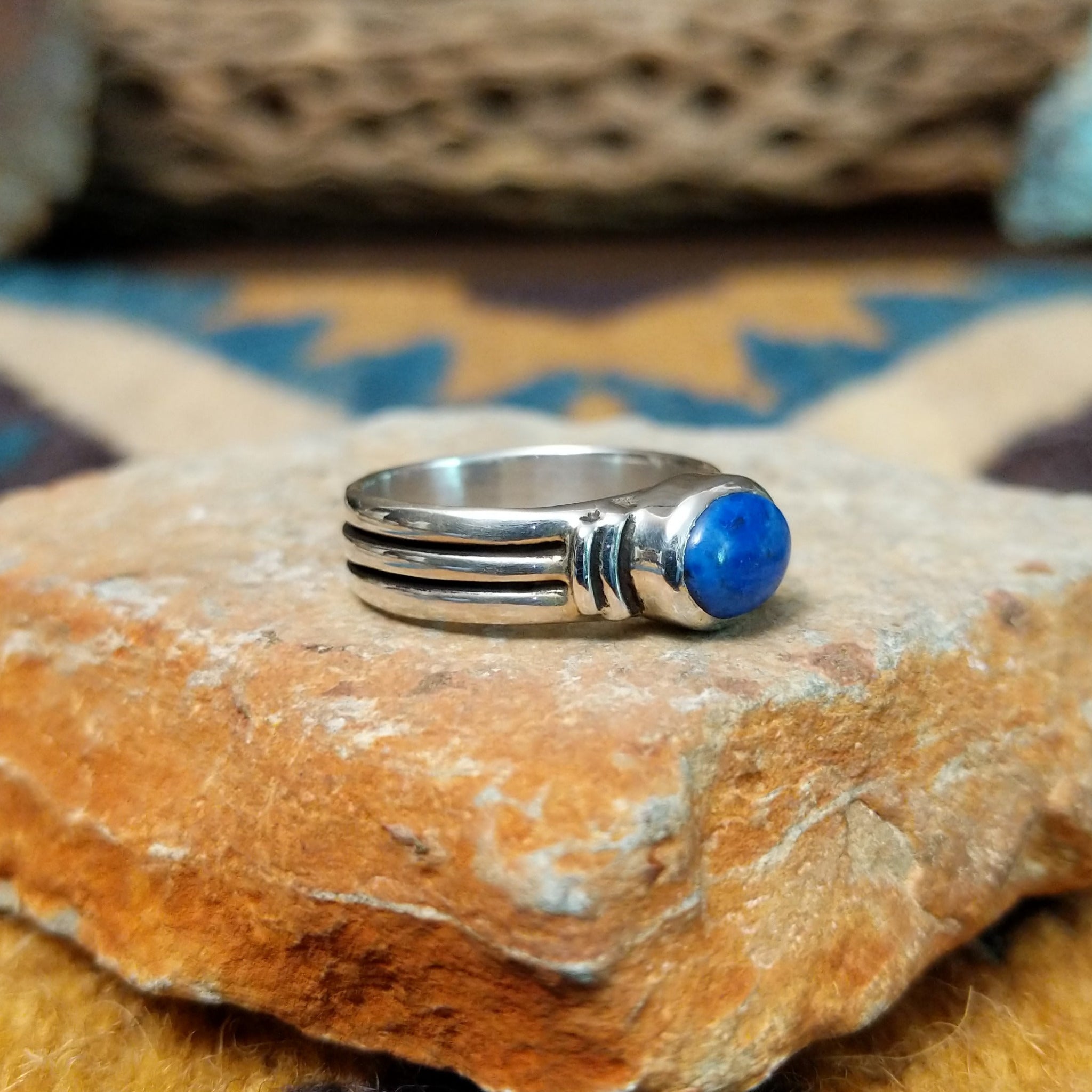 Handcrafted sterling silver Navajo lapis oval ring by D.C., featuring a rich blue oval lapis gemstone in a classic bezel setting; side view.