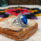 Navajo lapis ring by P. with oval blue stone, twisted silver border, and stamped details.