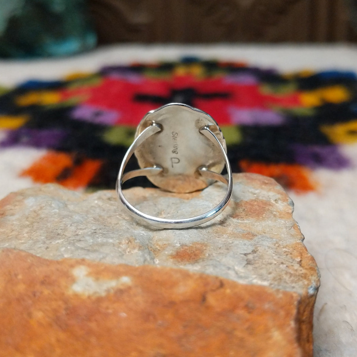 Navajo lapis ring by P. with oval blue stone, twisted silver border, and stamped details.