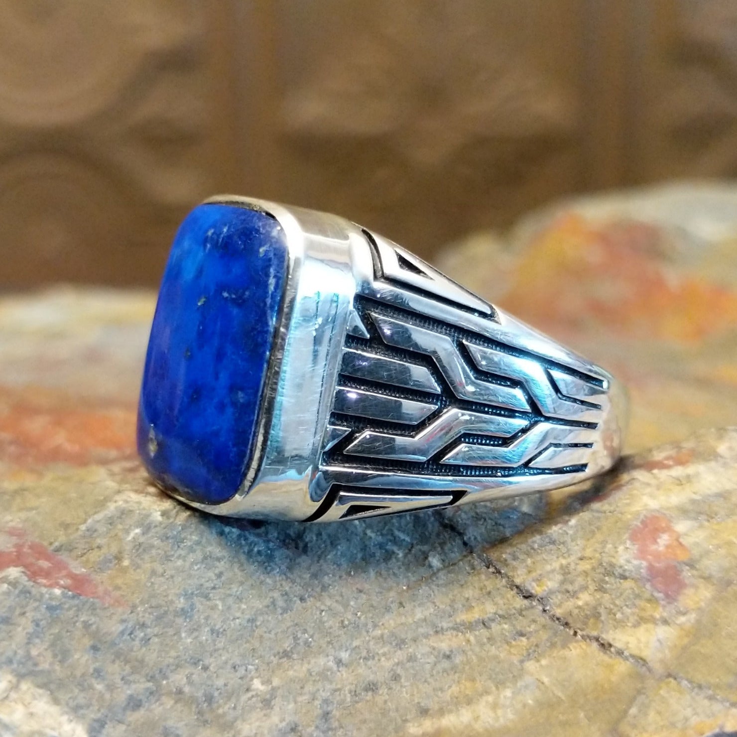 Sterling silver ring with lapis set in the rectangular bezel and geometric designs on the band.