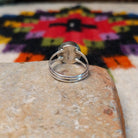 This captivating Navajo Lapis Round Ring features a polished round royal-blue lapis stone with natural mineral markings, set in a simple silver bezel with an open split-shank band; underside view.