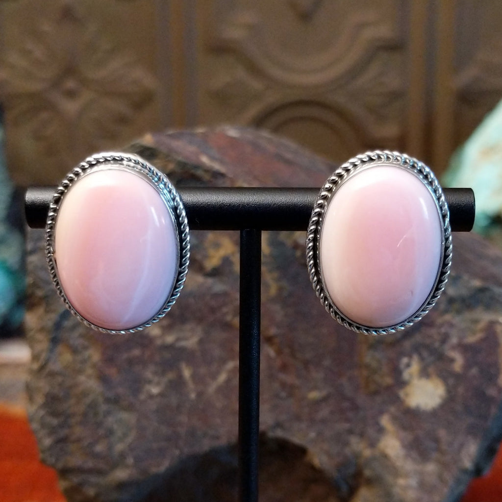 Large pink conch shell set within a sterling silver bezel with twisted rope accents.