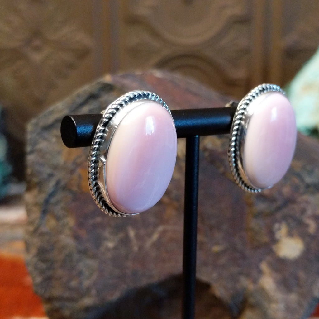 Large pink conch shell set within a sterling silver bezel with twisted rope accents.