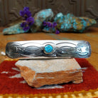 Sterling silver Navajo barrette with stamped detailing and centered turquoise stone.