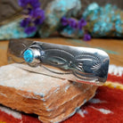 Sterling silver Navajo barrette with stamped detailing and centered turquoise stone.