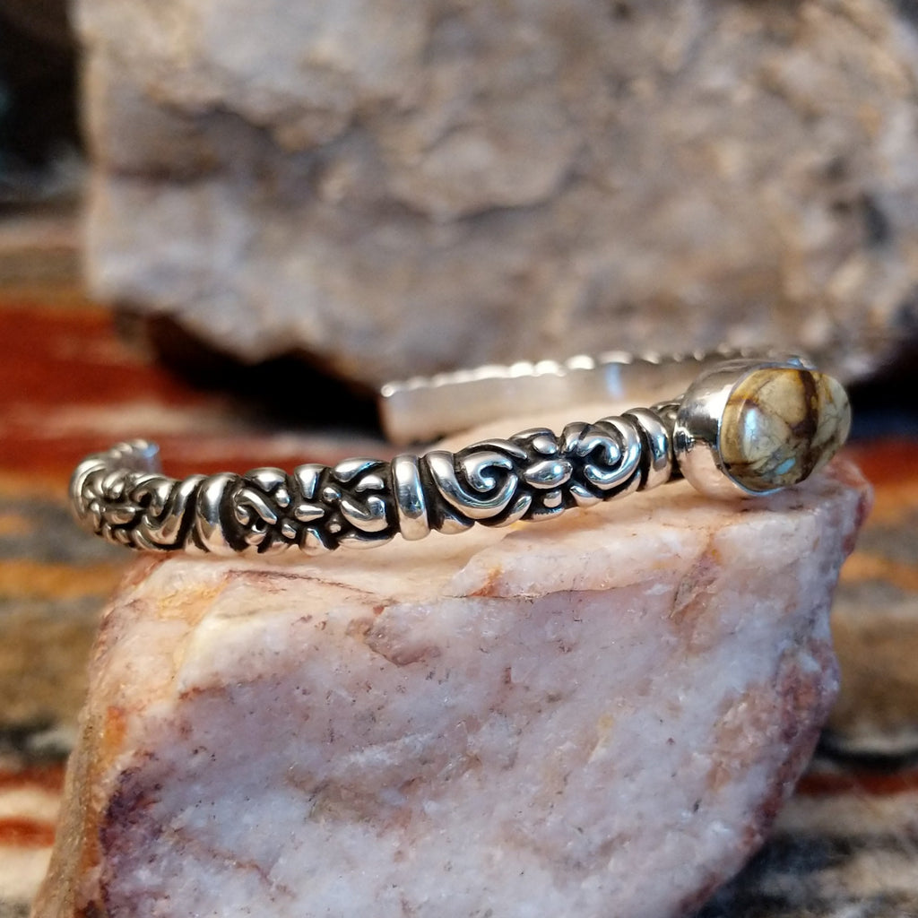 Boulder turquoise set in an oval bezel with intricate stamping on the band of the cuff.