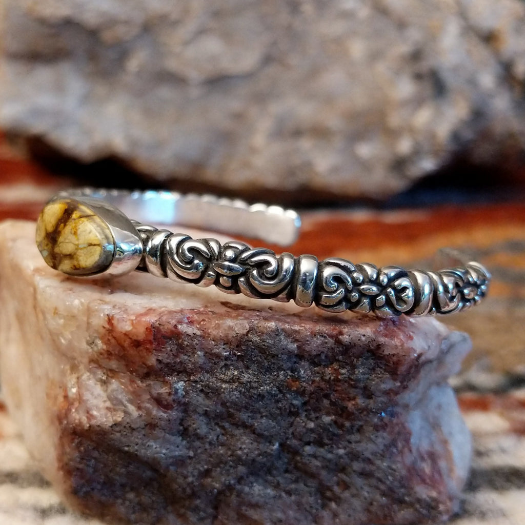 Boulder turquoise set in an oval bezel with intricate stamping on the band of the cuff.