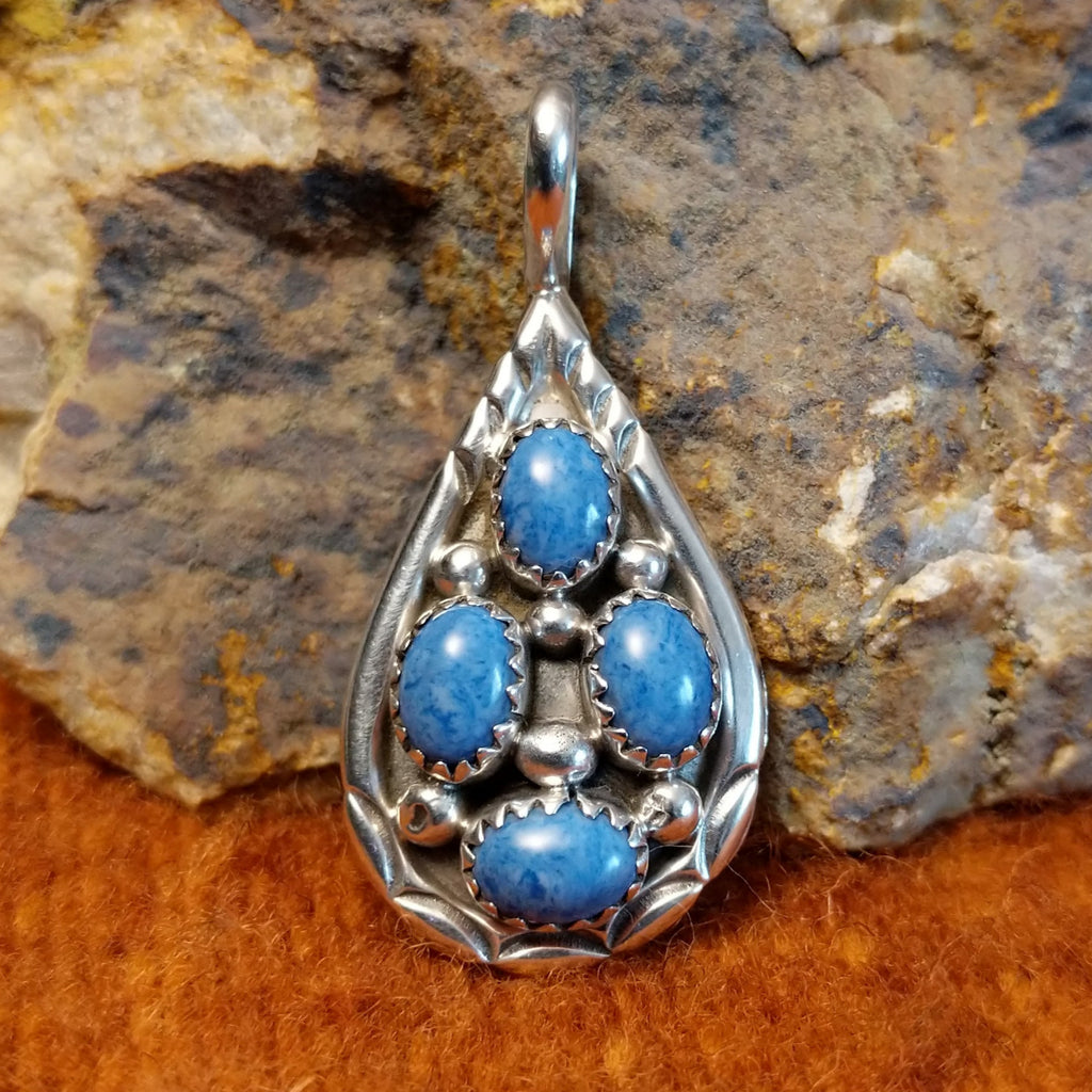 Four denim lapis stones set in notched sterling silver bezels on a sterling silver frame.
