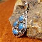Four denim lapis stones set in notched sterling silver bezels on a sterling silver frame.
