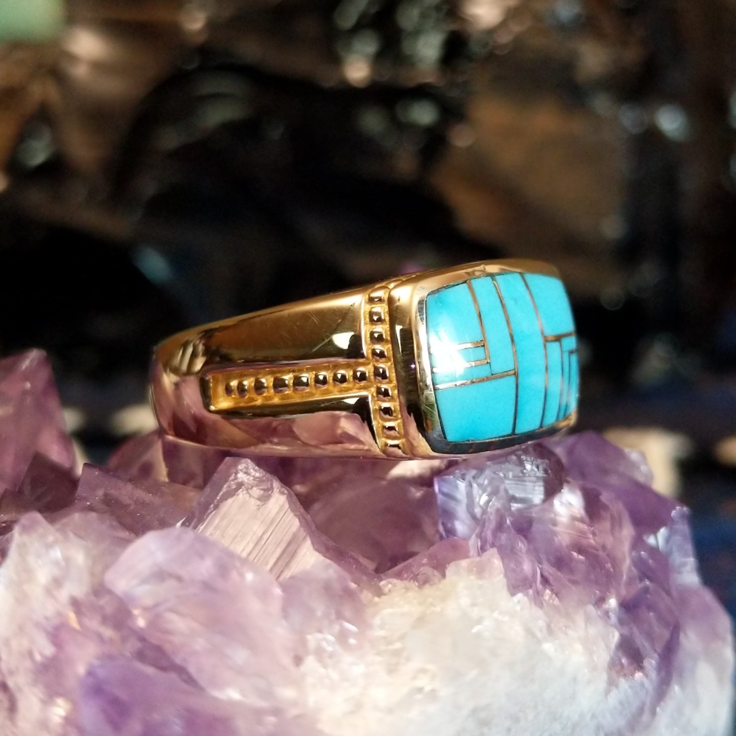 Gold ring featuring a rectangular turquoise inlay set in gold with a detailed band.