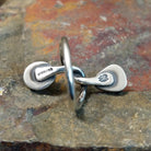 Silver ring with entwined band on the inner side, no stones visible. Smooth silver finish with stamp.
