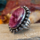 Star and dotted accents on the setting with an oval purple spiny oyster shell set inside it.