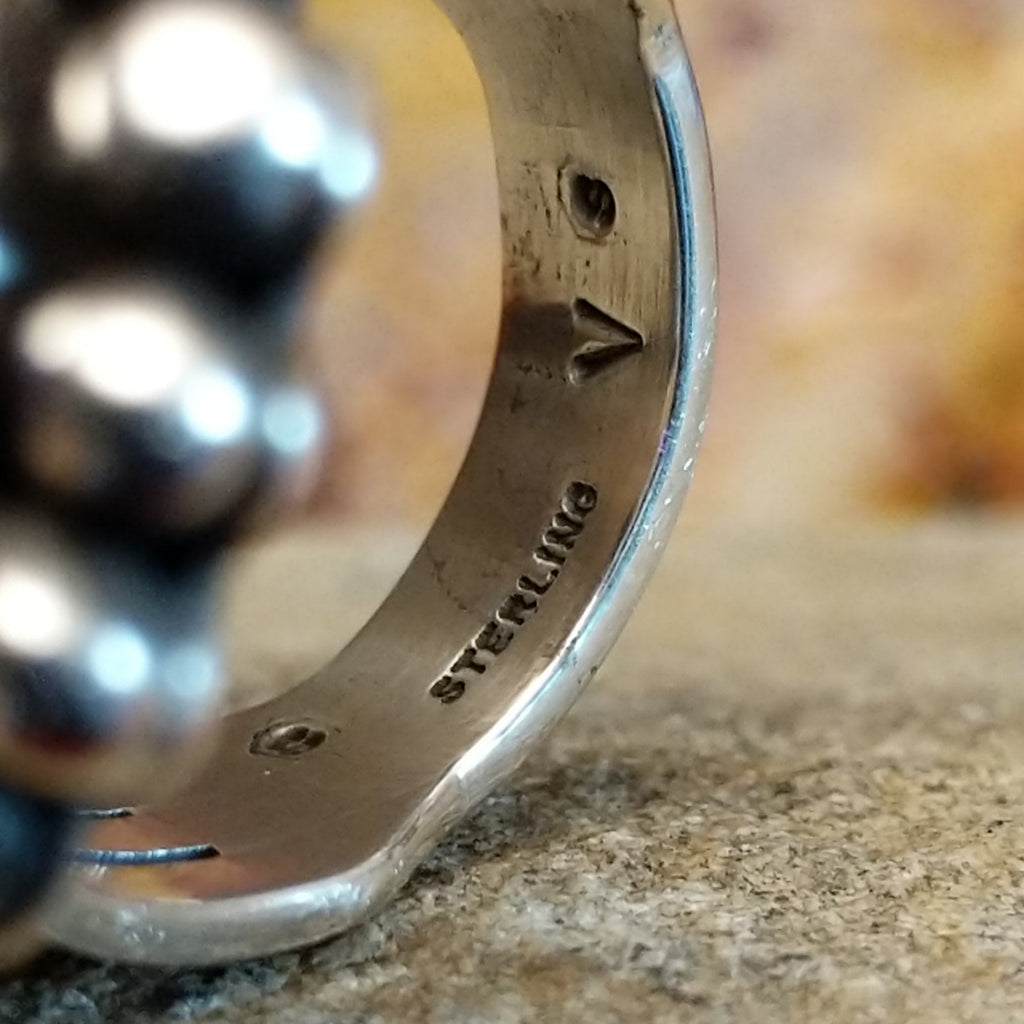 The underside of the band features the authentication and artisan's initial.