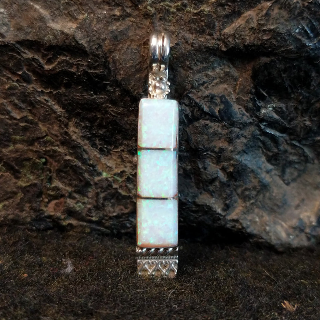 Manmade opal inlaid in sterling silver in the shape of a bar.