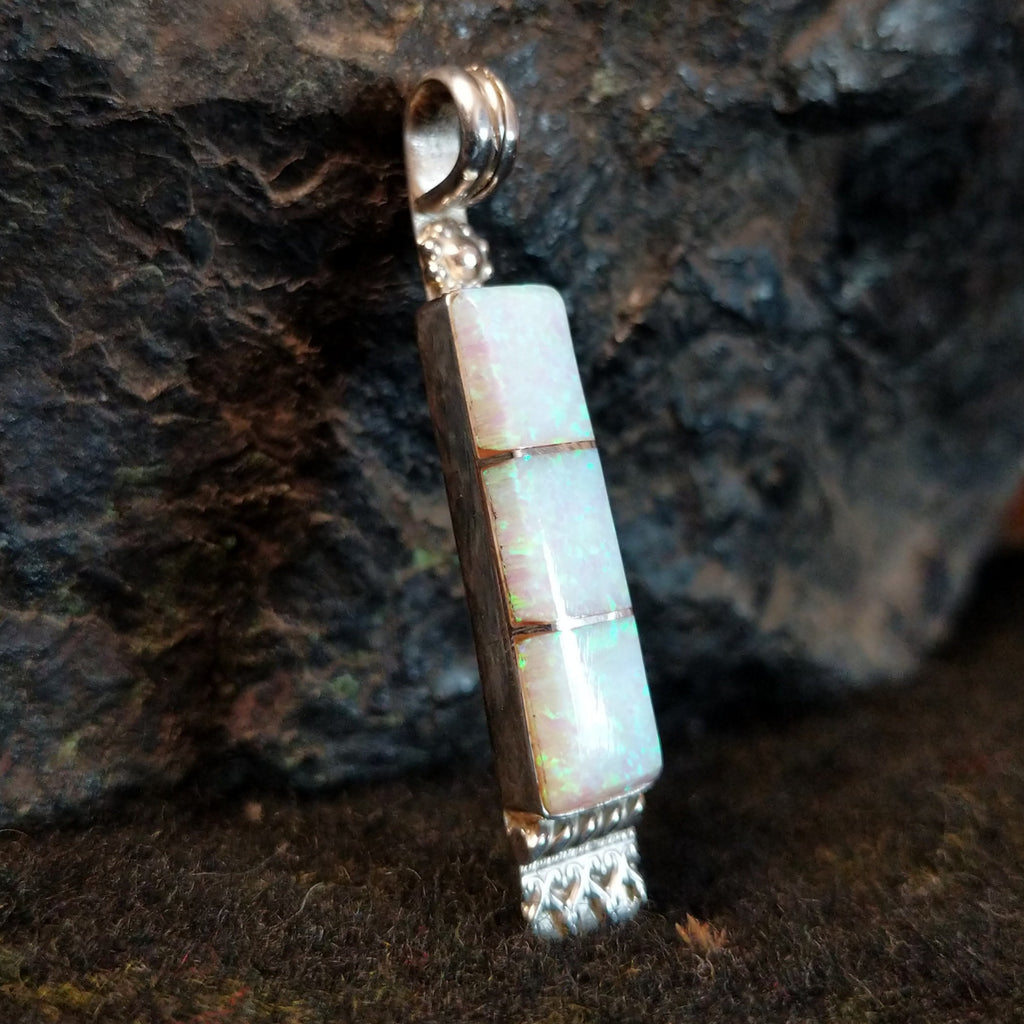 Manmade opal inlaid in sterling silver in the shape of a bar.