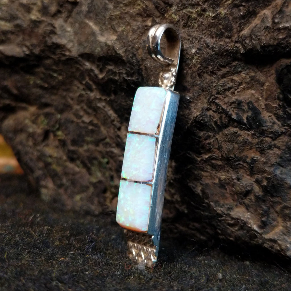 Manmade opal inlaid in sterling silver in the shape of a bar.