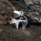 The back of the pendant features the authentication stamp.