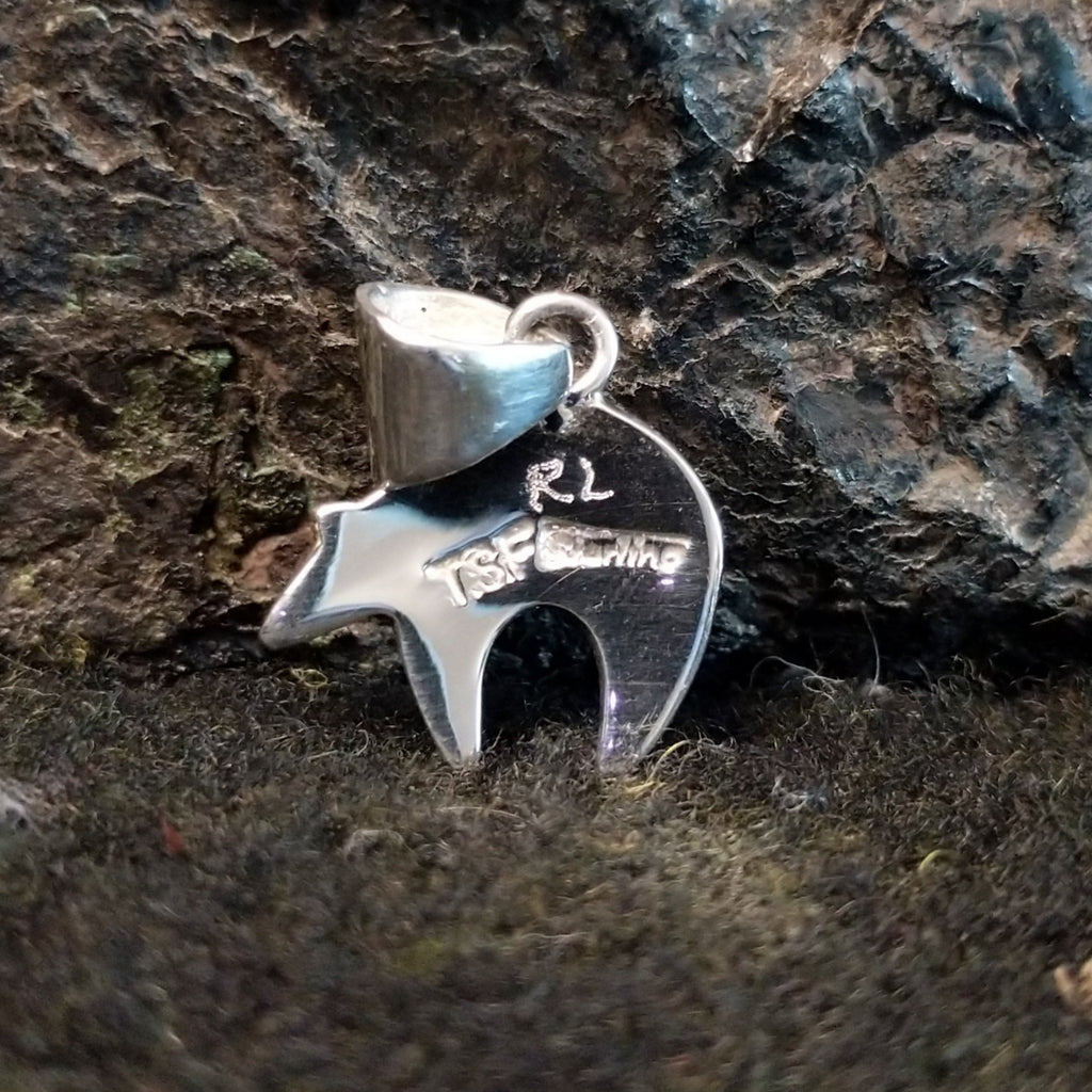 The back of the pendant features the authentication stamp.