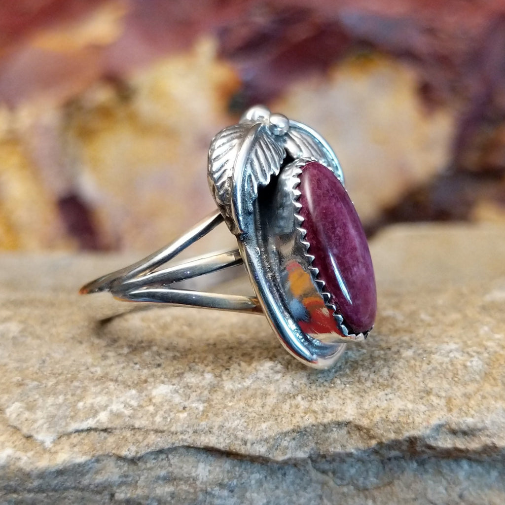 Oval purple spiny oyster shell in a notched bezel with feather motifs.