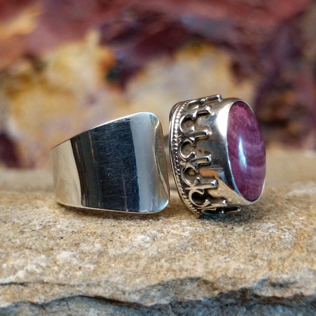 Oval purple spiny oyster shell in a raised bezel with intricate accents and a smooth band.