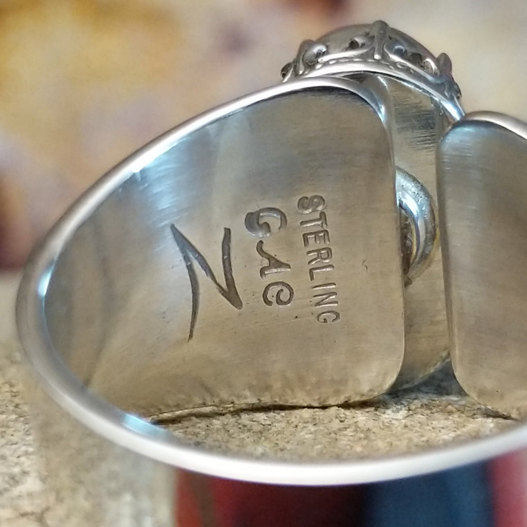 The initials are stamped on the underside of the band.