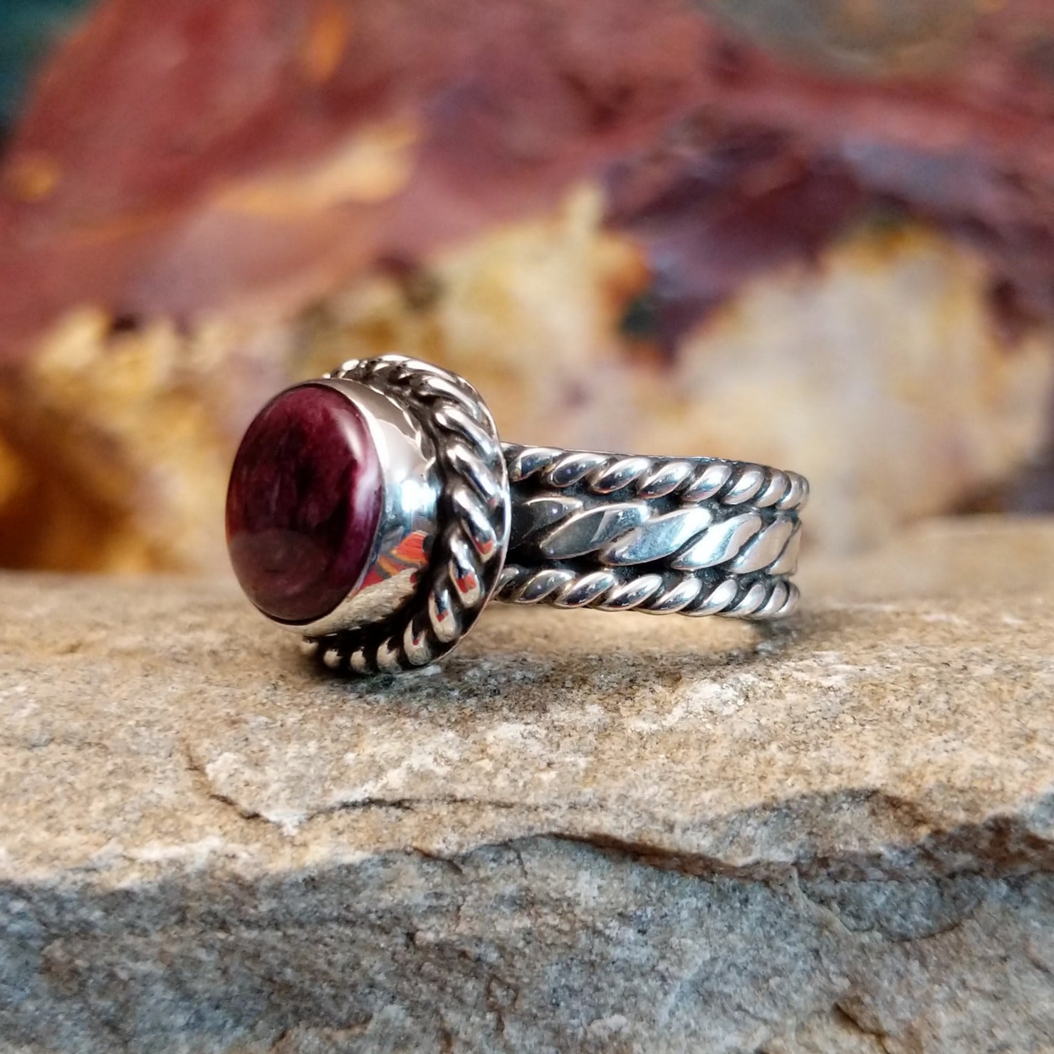 Purple spiny oyster shell set in a twisted rope bezel.