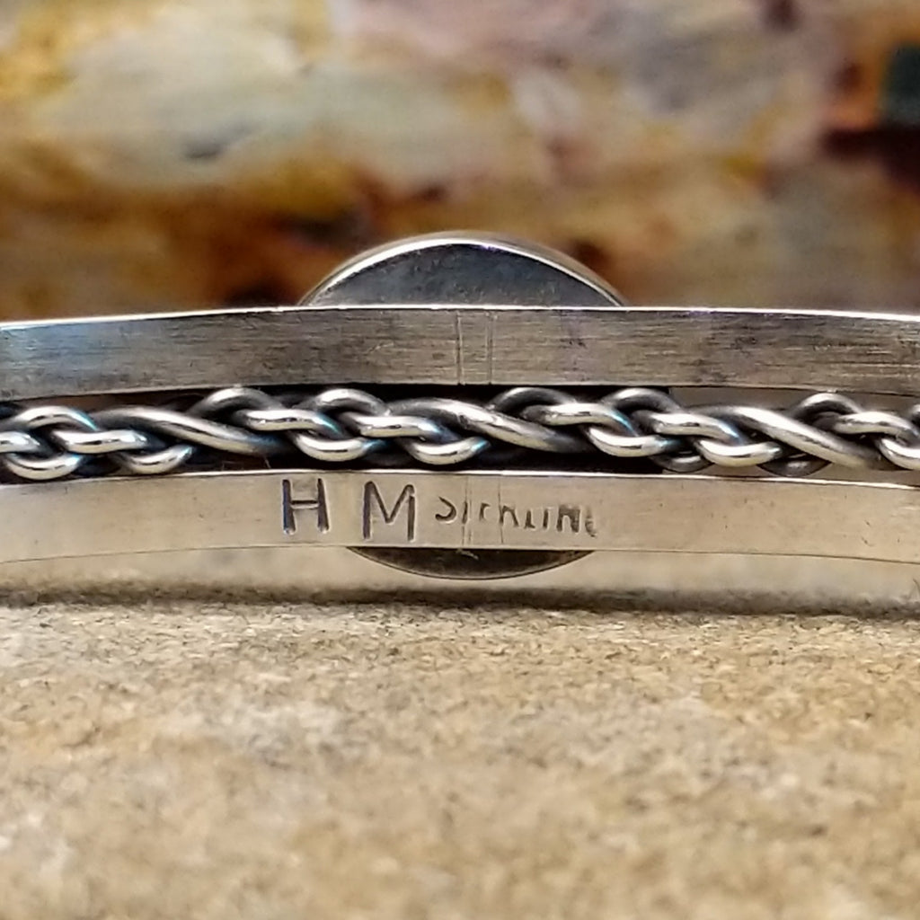 The artist's initials are stamped into the inside of the band.