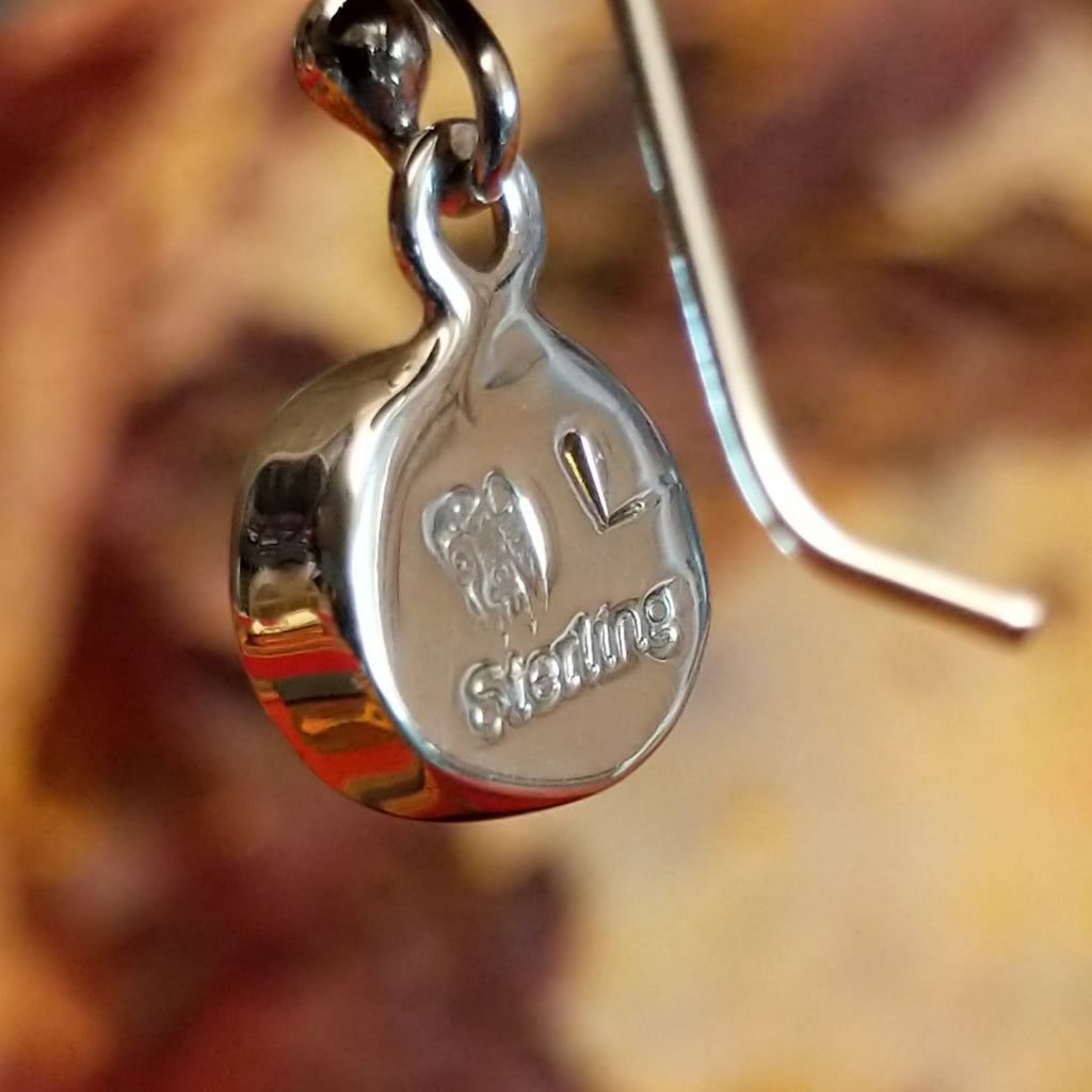 The backing's feature the artisan's stamped initial.