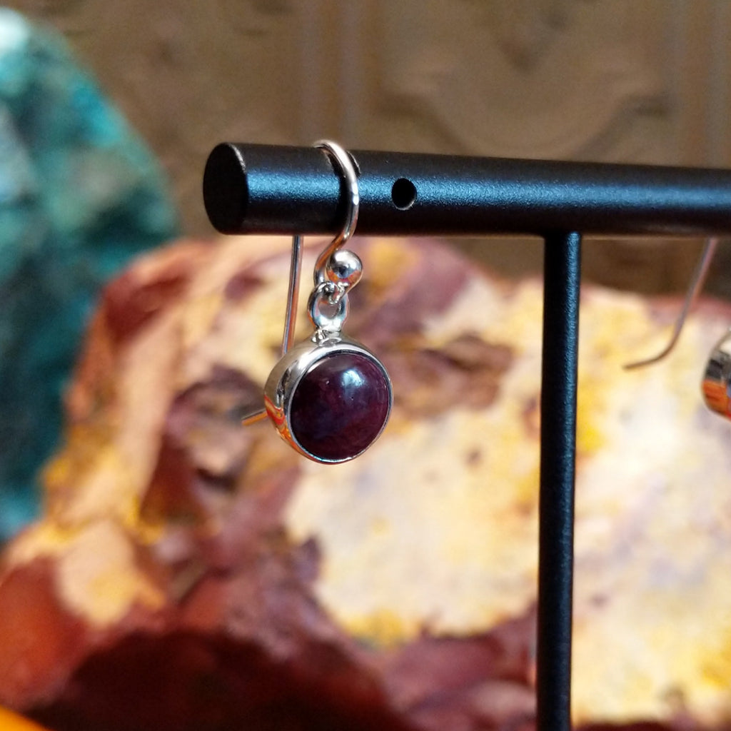 Small circular purple spiny oyster shell set in sterling silver with dangle hooks.