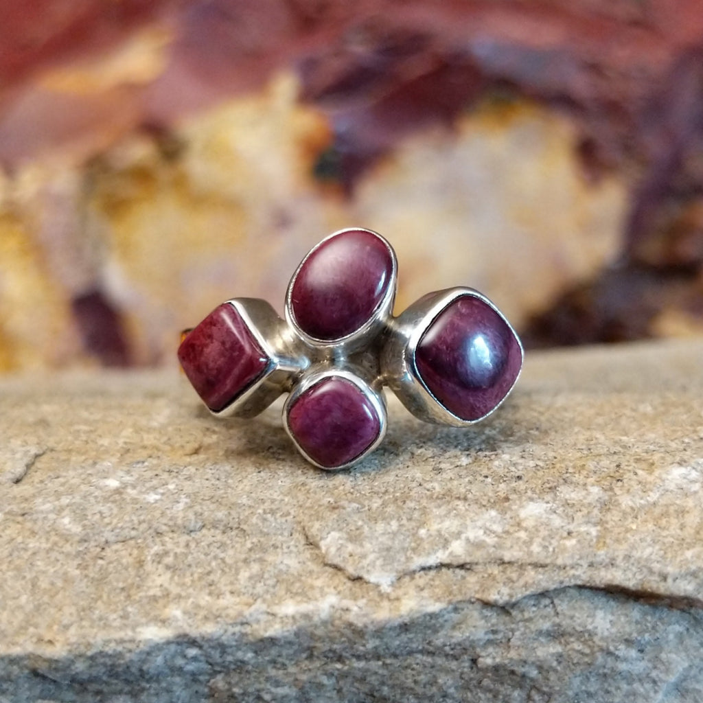 Four purple spiny oyster shells clustered together on a thin sterling silver band.
