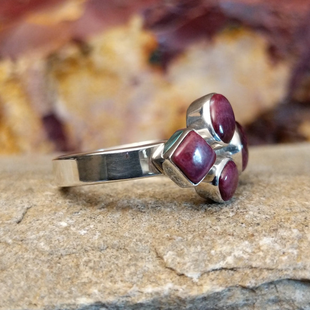 Four purple spiny oyster shells clustered together on a thin sterling silver band.